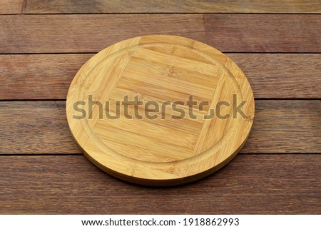 Round bamboo board on wooden background