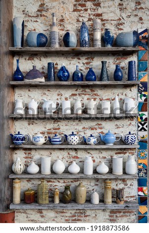 Ceramic Bottles, Ceramic Vases Ceramic kettle with antique paint glazed on an old wooden shelf attached to the decaying brick wall