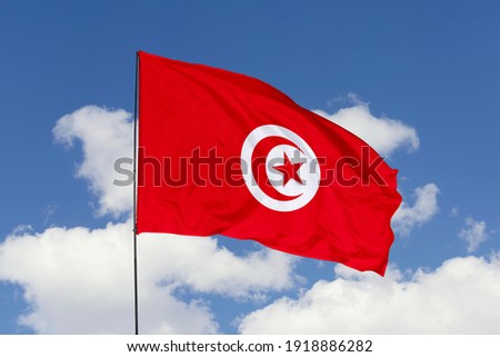Tunisia flag isolated on the blue sky with clipping path. close up waving flag of Tunisia. flag symbols of Tunisia.