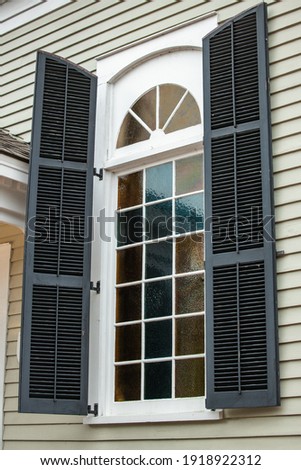 Large exterior view of a window with a curved semi circle top portion Royalty-Free Stock Photo #1918922312