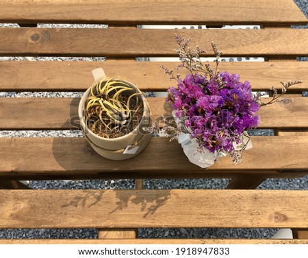 Frame a picture of purple lavender in a vase placed on a wooden table in a coffee shop.