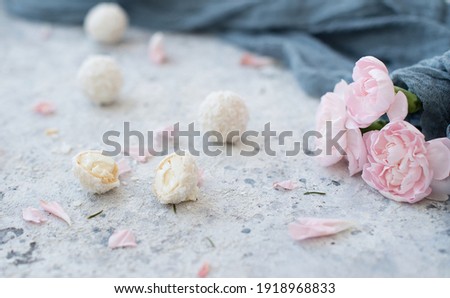 coconut balls with sprigs of roses on a gray background