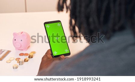  African american black man using mobile app for investing. Green screen on smartphone. High quality photo