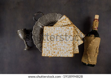 Jewish pesach attributes in composition a cup full of wine and passover matzah Royalty-Free Stock Photo #1918994828