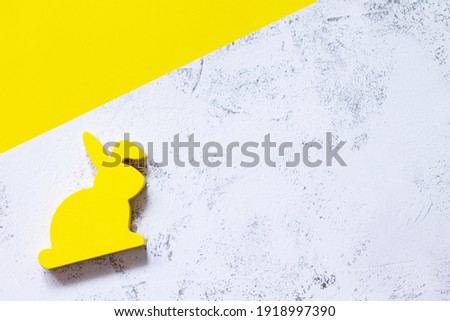 Minimal Easter concept. Yellow bunny on Illuminating Yellow and Ultimate Gray Color of the year 2021. Top view flat lay background. Copy space.