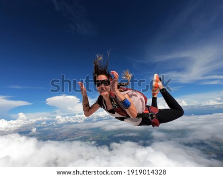 Young woman parachutist smiling in free fall. Perfect concept of happiness and freedom. Royalty-Free Stock Photo #1919014328