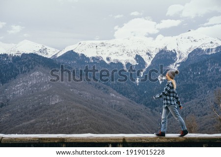 Beautiful young woman on a background of snowy mountains