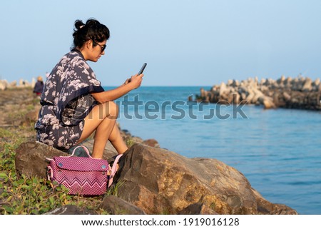young woman enjoying on the river bank with the sea in the background