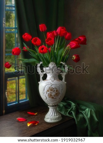 Still life with red tulips in antic vase