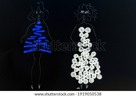 A drawing of two painted girls, whose dresses are made of berries and lemon slices, is photographed. The photo is converted to a negative effect.