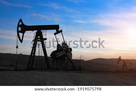 Oil drilling derricks at moutain oilfield for fossil fuels output and crude oil production from the ground. Oil drill rig and pump jack.