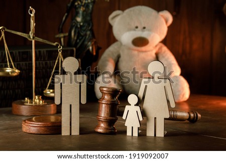 Wooden figures of family with teddy bear and gavel in a courtroom. Divorce and alimony concept Royalty-Free Stock Photo #1919092007