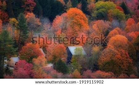 Old barn surrounded by colorful fall foliage 