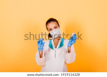 African-American doctor woman, mask, stethoskope, robe vaccine in studio
