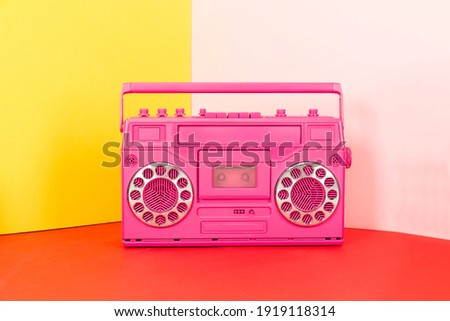 colored cassette player on pink and red background Royalty-Free Stock Photo #1919118314