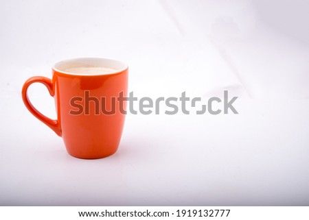 Orange mug with coffee isolated on a white background