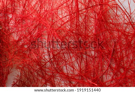 Abstract image texture is red with a chaotic mesh of thread. Christmas background.