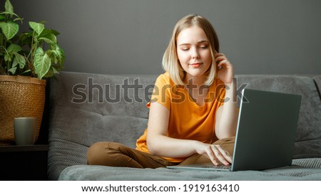 Pensive Caucasian beautiful woman work using laptop remotely from home. Portrait of teenage girl student thinking at home in living room studying online. Remote education via laptop. Long web banner.
