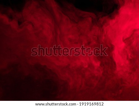 Abstract background of chaotically mixing puffs of red smoke on a dark background