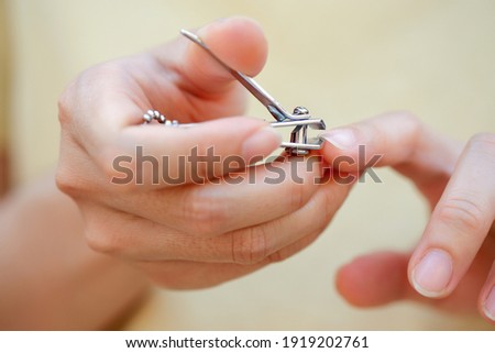 Closeup of women's fingernails are being cut and decorated with nail clippers, health care concept, selective focus.