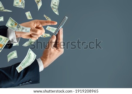 A hand from a smartphone transfers money and dollars fly out. Online cash transactions, mobile payments using a smartphone. Concept Financial growth, passive income, online business, dividends Royalty-Free Stock Photo #1919208965