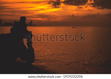 Silhouette photographer with nature sunset background