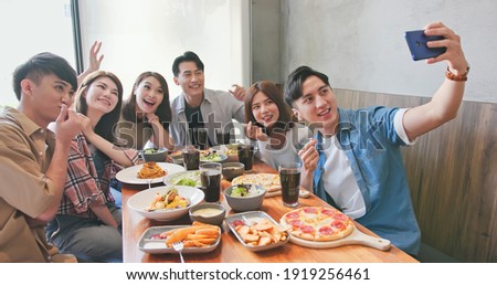 asian young six friends taking selfie in restaurant happily