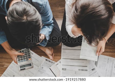 Top view asian couple sitting on the floor stressed and confused by calculate expense from invoice or bill,have no money to pay think of taking the house to mortgage causing debt,bankruptcy concept. Royalty-Free Stock Photo #1919257880