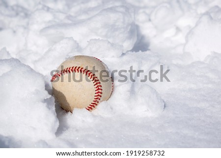 A baseball buried in the snow