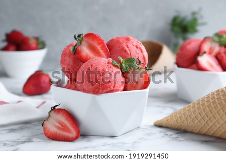 Yummy strawberry ice cream on white marble table