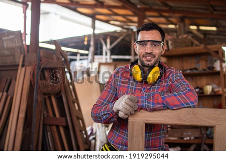 carpenter is working in a woodworking office.Worker Portrait caucasion white Carpenter standing and looking at camera Royalty-Free Stock Photo #1919295044