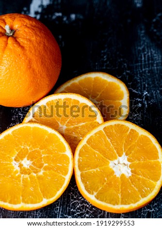 orange on a black background. Orange slices on a craquelure board. Close-up