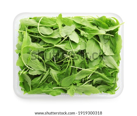 Fresh arugula in plastic container isolated on white, top view Royalty-Free Stock Photo #1919300318