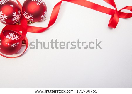 A Christmas balls and a red ribbon on a white background