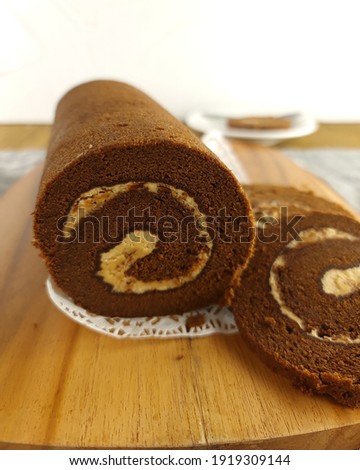 Kue Bolu Gulung Coklat or  Chocolate roll cake on wooden board. Cake for Ramadhan and Idul Fitri, The Great Islamic Day