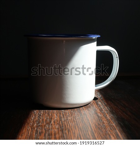 a photo with a panoramic view of the sunlight shining on a white cup     