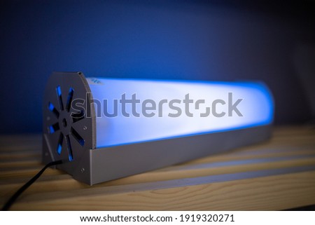 
glowing ultraviolet lamp on a wooden shelf
