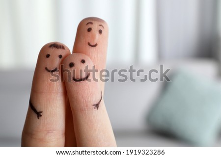 Three fingers with drawings of happy faces on blurred background, space for text