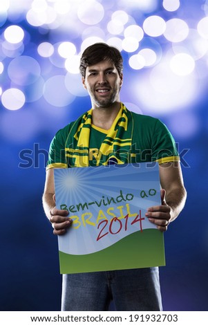 Brazilian Fan holding a welcome to Brazil sign, (Bem-vindo ao Brasil), written in Portuguese., on a blue background.