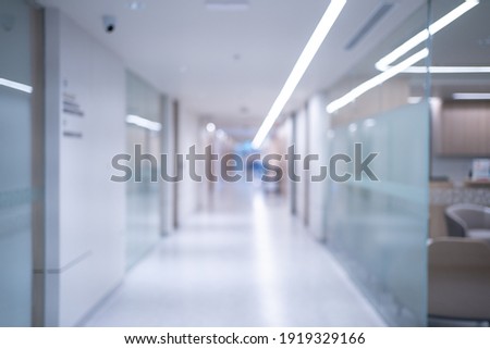 Blurred background of an interior of a modern hospital with an empty long corridor, there are treatment rooms and waiting room for patients and families between the corridor with bright white lights. Royalty-Free Stock Photo #1919329166