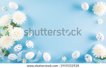 Happy easter! Colourful of Easter eggs in with flower on pastel blue background. Greetings and presents for Easter Day celebrate time. Flat lay ,top view.