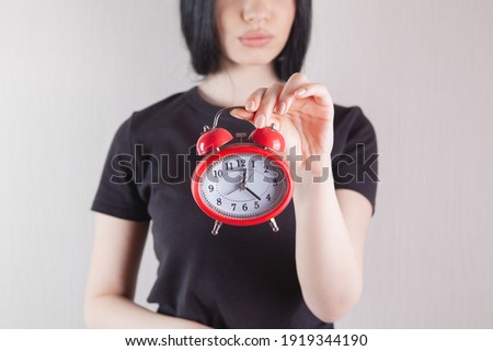 girl holding an alarm clock