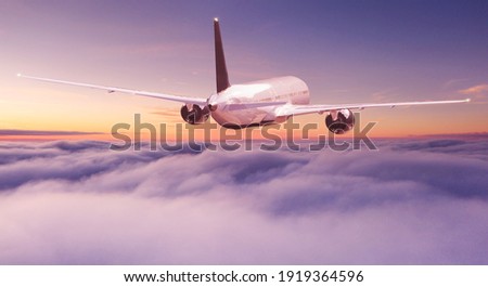 Commercial airplane jetliner flying above dramatic clouds in beautiful light. Travel concept. Royalty-Free Stock Photo #1919364596