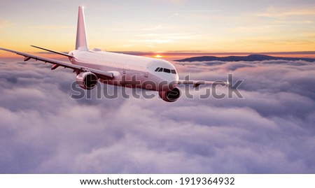 Commercial airplane jetliner flying above dramatic clouds in beautiful light. Travel concept. Royalty-Free Stock Photo #1919364932