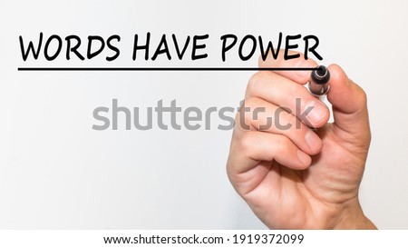 the hand writes text WORDS HAVE POWER with a marker on a white background. business concept