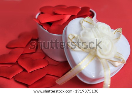 White gift box and red hearts on yred  background. Symbol of love, romantic.  Concept holiday. Happy Woman's Day, Mother's Day, Valentine's Day, Wedding