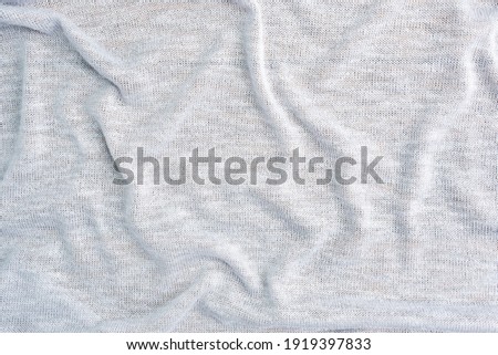 Background is made of gray textile material, the texture of a piece of clothing.