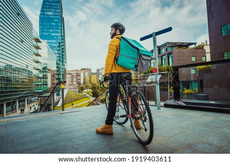 Food delivery service, rider delivering food to clients with bicycle - Concepts about transportation, food delivery and technology Royalty-Free Stock Photo #1919403611
