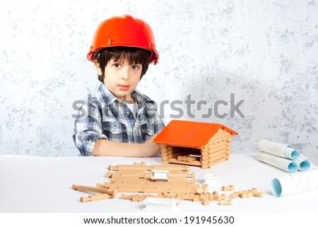 boy builder in red helmet  built a new home