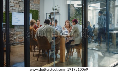 Diverse Group of Professional Businesspeople Meeting in the Modern Office Conference Room. Creative Team Discuss App Design, Analyze Data, Plan Marketing Strategy, Disrupt Social Media, Growth Hack Royalty-Free Stock Photo #1919510069